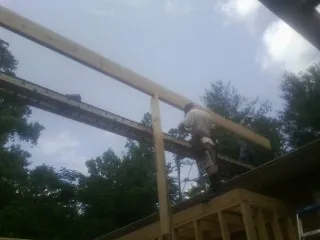 Carpenter setting a ridge beam over a new addition frame — Ice Dam Removal by Roofing Brothers in Hysham