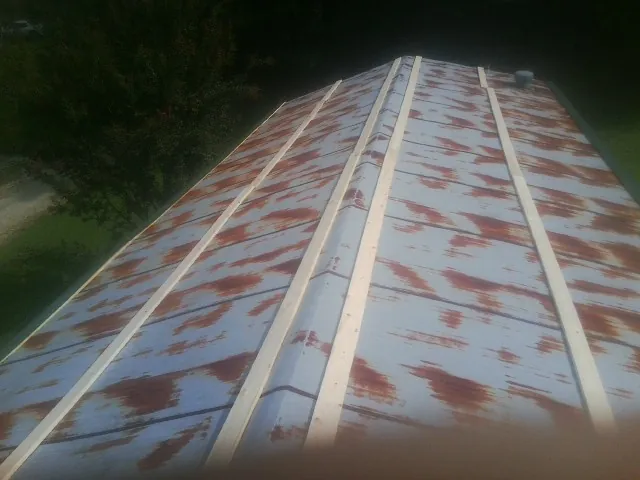Rusted metal roof panels with new wood purlins before replacement — Storm Damage Roof Repair in Hysham by Roofing Brothers